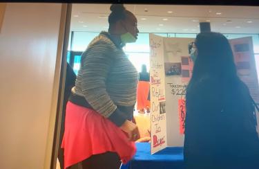 Jakia Carroll of PFFC is engaging with a Constituent about her Poster on Child and Family Sevices at the Safety Summit. 